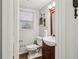 Compact half-bathroom featuring a stylish vanity with a white sink and a window with blinds at 1922 Olde Village Run, Dunwoody, GA 30338