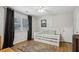Bedroom with a daybed, wood floors, and bright windows covered with dark curtains at 1922 Olde Village Run, Dunwoody, GA 30338