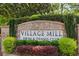 Brick sign for Village Mill Swim & Tennis Club surrounded by landscaping at 1922 Olde Village Run, Dunwoody, GA 30338