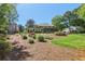 Rear exterior view of the home features a manicured lawn with mature trees at 1922 Olde Village Run, Dunwoody, GA 30338