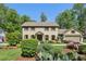 Two-story brick home featuring mature landscaping, and a two-car garage at 1922 Olde Village Run, Dunwoody, GA 30338