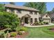 Charming brick two-story home with well-manicured landscaping, a two-car garage, and mature trees at 1922 Olde Village Run, Dunwoody, GA 30338