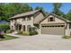 Traditional two-story home with brick and siding, a large driveway and manicured landscaping at 1922 Olde Village Run, Dunwoody, GA 30338