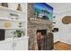 Stone fireplace with built-in shelving and a television above the mantle creating a cozy focal point at 1922 Olde Village Run, Dunwoody, GA 30338