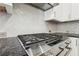 Modern kitchen featuring stainless steel range and herringbone backsplash at 1922 Olde Village Run, Dunwoody, GA 30338