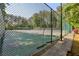 Outdoor tennis court surrounded by a chain-link fence and lush landscaping at 1922 Olde Village Run, Dunwoody, GA 30338