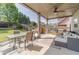 Spacious covered back patio with seating, table, and outdoor fan, perfect for relaxing and entertaining at 230 Wild Barley Way, Loganville, GA 30052