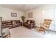 Cozy bonus room featuring comfortable leather sofas, a rocking chair, and neutral carpet at 230 Wild Barley Way, Loganville, GA 30052