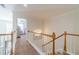 Upstairs hallway with carpeted floors, white railing, and access to the bedrooms at 230 Wild Barley Way, Loganville, GA 30052