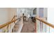 Carpeted upstairs hallway with white railing and views into the bedrooms at 230 Wild Barley Way, Loganville, GA 30052
