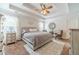 Tranquil main bedroom with a tray ceiling, large windows, and comfortable furnishings at 230 Wild Barley Way, Loganville, GA 30052