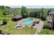 Aerial view of a backyard with a pool, outdoor seating, a cabana, a hot tub and well-maintained landscaping at 5010 Heardmont Trace Rd, Cumming, GA 30028