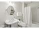 Clean and simple bathroom with pedestal sink, toilet, and shower with a curtain at 5010 Heardmont Trace Rd, Cumming, GA 30028