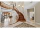 Grand foyer showcasing a curved staircase, tile flooring, and views to living spaces at 5010 Heardmont Trace Rd, Cumming, GA 30028