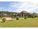 Charming home exterior features a manicured lawn, mature trees, and a circular driveway leading to a grand entrance at 5010 Heardmont Trace Rd, Cumming, GA 30028
