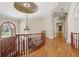 Upstairs hallway with hardwood flooring, crown molding, and a decorative light fixture at 5010 Heardmont Trace Rd, Cumming, GA 30028