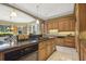Spacious kitchen with a center island cooktop, granite counters, wooden cabinets, and modern appliances at 5010 Heardmont Trace Rd, Cumming, GA 30028