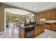 Spacious kitchen has center island with cooktop, granite counters, wooden cabinets, and an adjacent breakfast nook at 5010 Heardmont Trace Rd, Cumming, GA 30028