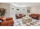 Living room features a set of brown leather sofas with windows overlooking the lawn at 5010 Heardmont Trace Rd, Cumming, GA 30028