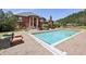 A luxurious pool is surrounded by a brick patio, lounge furniture, and a landscaped lawn at 5010 Heardmont Trace Rd, Cumming, GA 30028