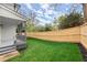 Exterior view of a backyard with a gray porch, wood fence, and an expanse of lush green grass at 779-B Lynwood Se St, Atlanta, GA 30312
