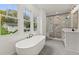 Modern bathroom features a free-standing tub, a glass-enclosed shower, and black fixtures at 779-B Lynwood Se St, Atlanta, GA 30312