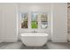 Serene bathroom features a freestanding tub positioned beneath three large windows offering an outdoor view at 779-B Lynwood Se St, Atlanta, GA 30312