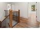 Hallway with hardwood floors and wood and iron railing staircase leading to an open doorway and a sunlit room at 779-B Lynwood Se St, Atlanta, GA 30312