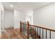 Hallway with hardwood floors and wood and iron railing staircase leading to an open doorway and a bright room at 779-B Lynwood Se St, Atlanta, GA 30312