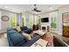 Living room featuring a comfortable blue sectional, fireplace, and abundant natural light at 986 Mauldin Se St, Atlanta, GA 30316