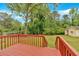 Relaxing backyard with a wooden deck overlooking a lush green lawn and mature trees at 115 Pine Tree Dr, Fayetteville, GA 30214