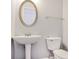 Elegant bathroom featuring a pedestal sink and a round mirror above the sink at 1150 Collier Nw Rd # 1N, Atlanta, GA 30318