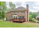 Expansive backyard showcasing a brick home with a wooden deck, perfect for outdoor entertaining at 1180 Oxford Dr, Conyers, GA 30013