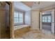 Bright bathroom featuring tiled floors, a tub, glass-enclosed shower, and access to another room at 1180 Oxford Dr, Conyers, GA 30013