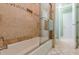 Tiled shower and tub with glass door, with decorative tile and a view to the exterior at 1180 Oxford Dr, Conyers, GA 30013