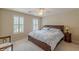 This bedroom has a ceiling fan, windows with shutters, carpet, and a large bed at 1180 Oxford Dr, Conyers, GA 30013