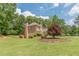A charming two-story brick home featuring lush green lawn, mature trees, and vibrant landscaping at 1180 Oxford Dr, Conyers, GA 30013