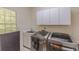 Well-equipped laundry room with modern washer and dryer and ample storage cabinets at 1180 Oxford Dr, Conyers, GA 30013