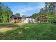 Backyard featuring a well-manicured lawn, treeline, privacy fence, and a covered outdoor gazebo at 5035 Villa Rica Hwy, Dallas, GA 30157