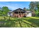 A view of the home's backyard featuring green grass, a wooden fence, a deck, and an outdoor gazebo at 5035 Villa Rica Hwy, Dallas, GA 30157