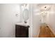 Bathroom featuring a modern vanity with dark wood cabinets, a sink, and a round mirror on a white wall at 5035 Villa Rica Hwy, Dallas, GA 30157