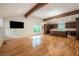 Open-concept living area with hardwood floors, vaulted ceiling, exposed beams, and kitchen view at 5035 Villa Rica Hwy, Dallas, GA 30157