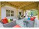 Spacious covered patio with comfortable lounge furniture and an outdoor dining area at 549 Greenridge Ln, Loganville, GA 30052