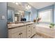 Well-lit bathroom featuring double sinks, soaking tub, and separate shower at 549 Greenridge Ln, Loganville, GA 30052