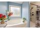 Relaxing bathroom with soaking tub under a window and stand-up shower stall at 549 Greenridge Ln, Loganville, GA 30052