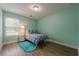 Bright bedroom with light-green walls, wood floors, a cozy bed, and a window with natural light at 549 Greenridge Ln, Loganville, GA 30052