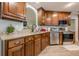 Charming kitchen with granite countertops, wood cabinets, and stainless steel appliances at 549 Greenridge Ln, Loganville, GA 30052
