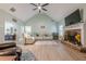 Cozy living room with a brick fireplace, ceiling fan, and large windows for ample natural light at 549 Greenridge Ln, Loganville, GA 30052