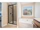 Bathroom with a shower and tub alongside a window offering natural light at 1057 Cotton Oak Dr, Lawrenceville, GA 30045