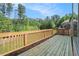 Outdoor wooden deck with a view of lush greenery and a clear blue sky at 1057 Cotton Oak Dr, Lawrenceville, GA 30045